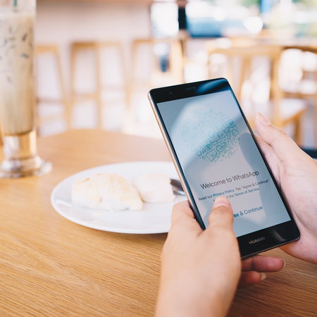 Person holding a smartphone displaying WhatsApp, as Spanish police warn of a scam targeting parents.