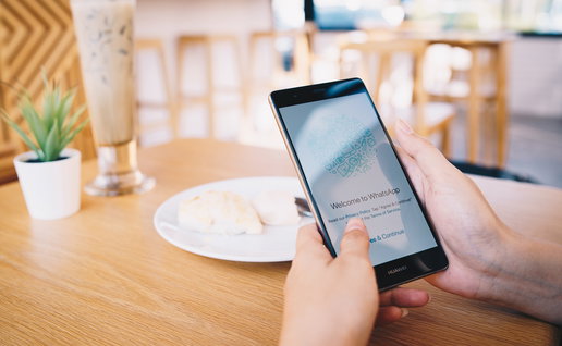 Person holding a smartphone displaying WhatsApp, as Spanish police warn of a scam targeting parents.